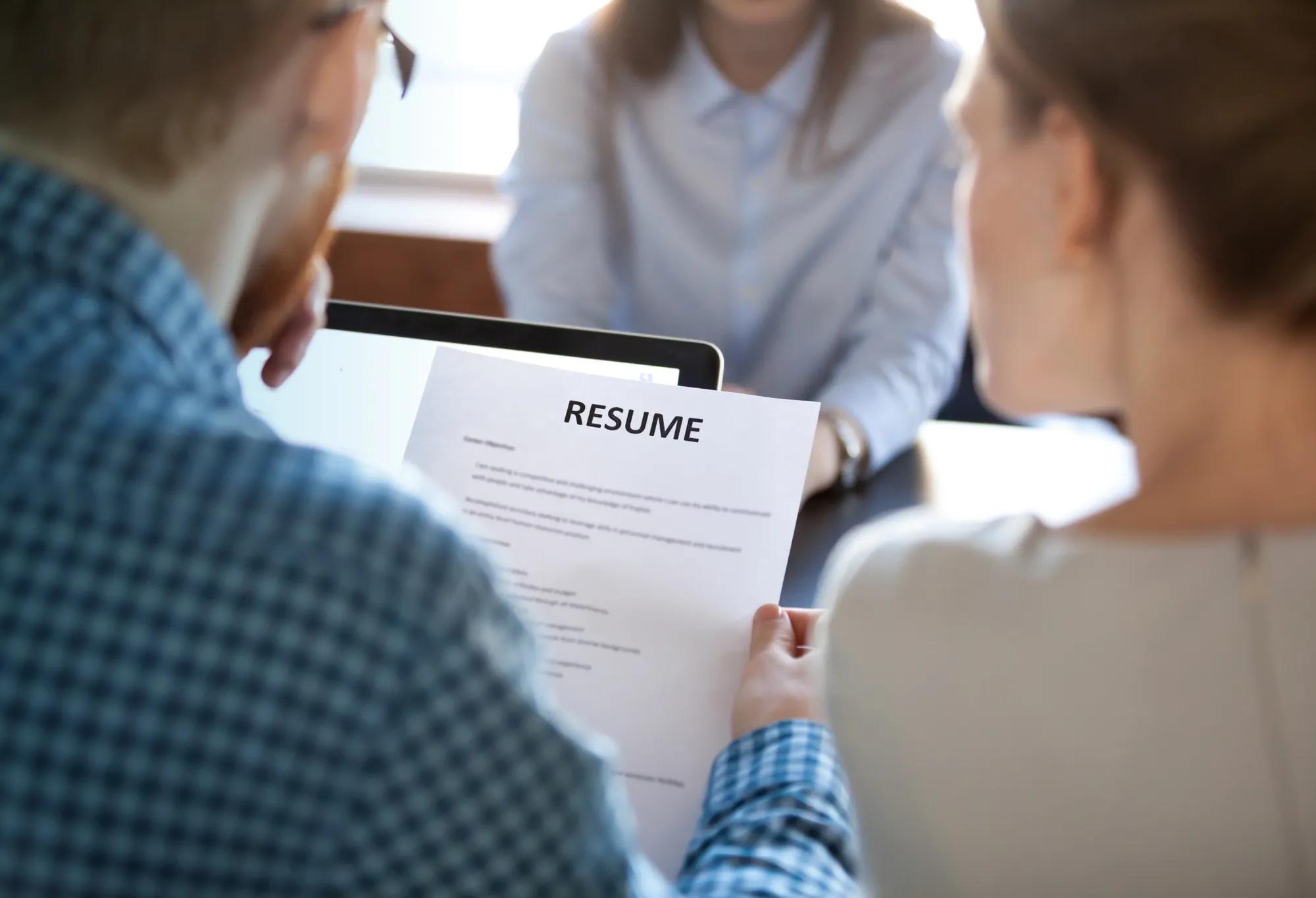 An employer looking at the resume of a healthcare job applicant during an interview