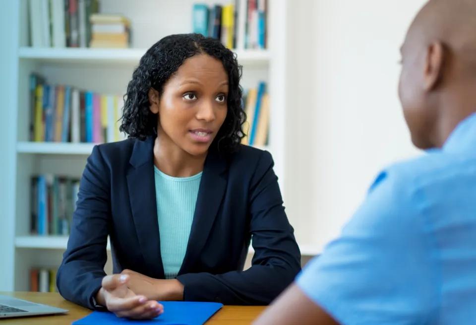an entry-level health and human services worker speaking with a client after completing HHS training
