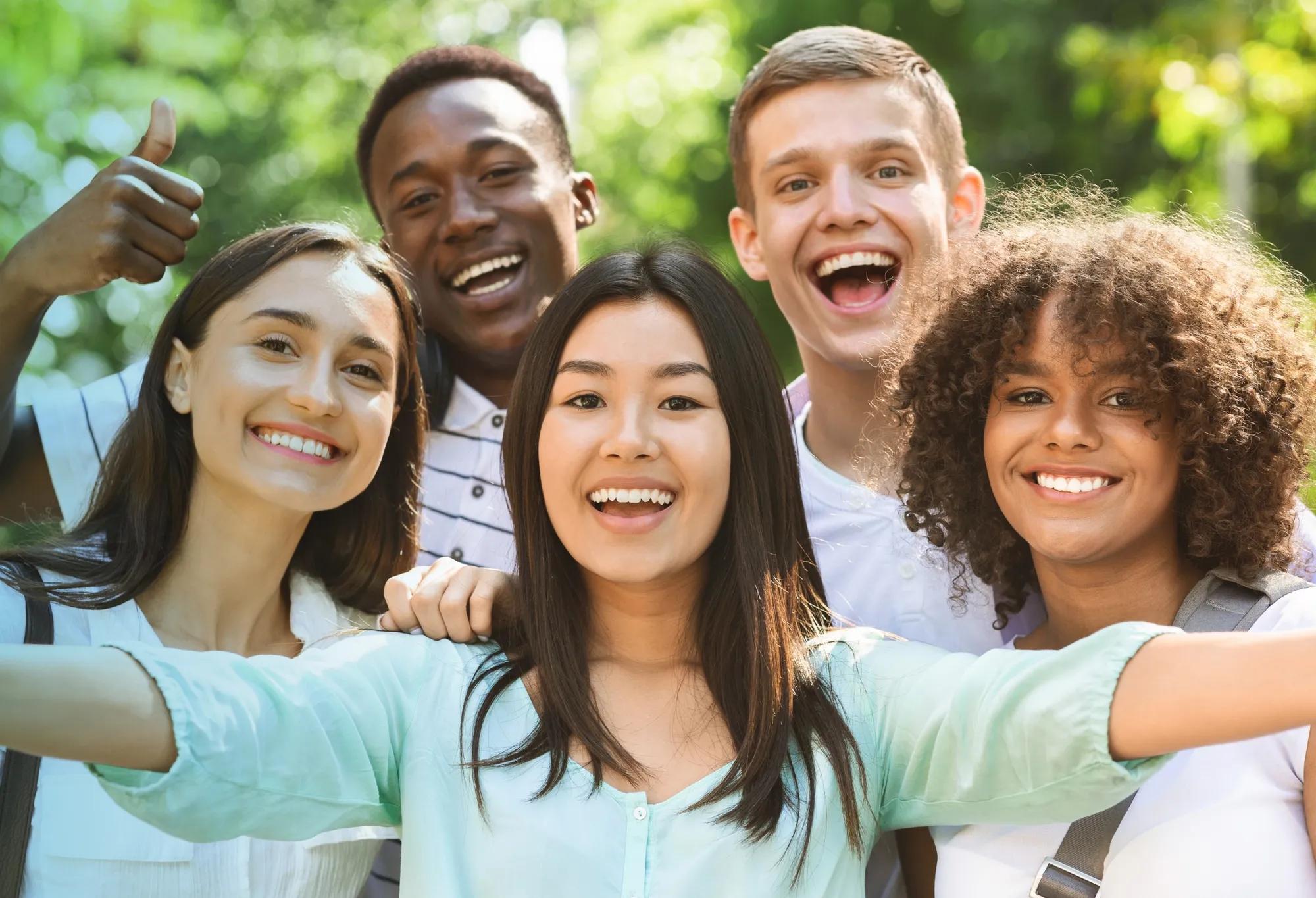 A group of friends smiling and laughing while acting as each other's support system