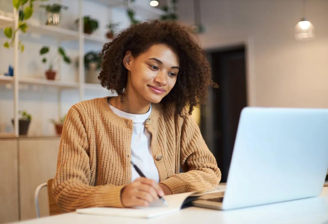 a woman working on her pharmacy technician resume after completing a pharmacy tech training program