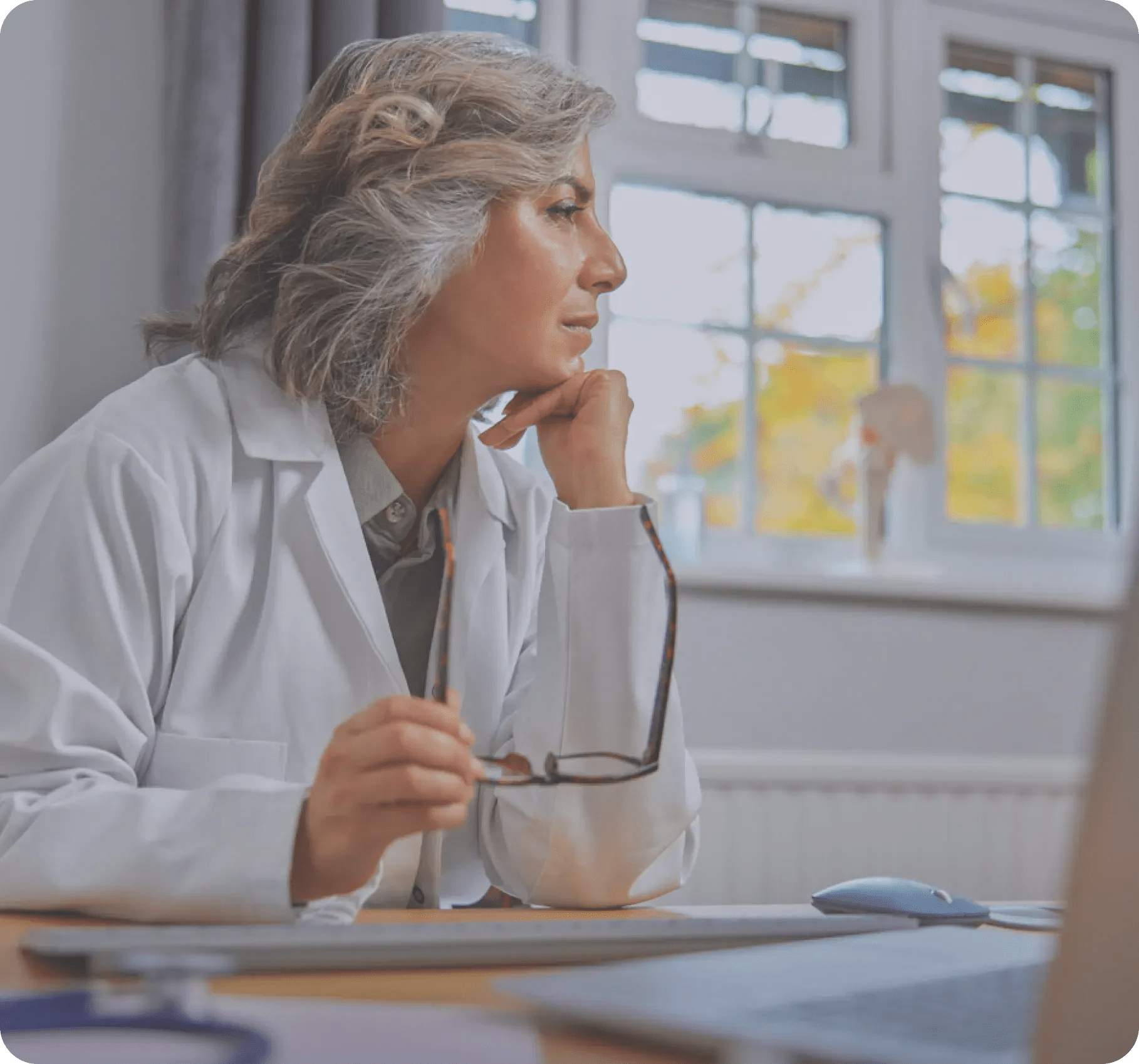 a woman wearing white coat looking at laptop