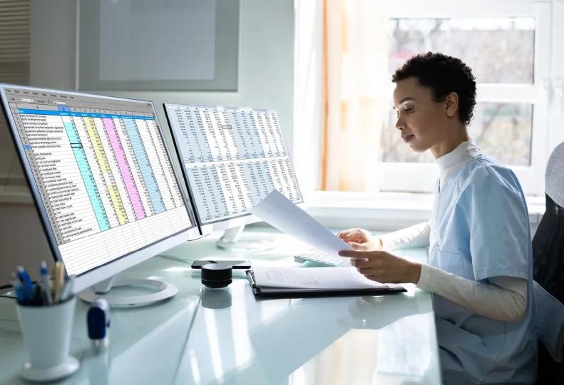 a medical biller and coder working on a computer after completing medical billing and coding training