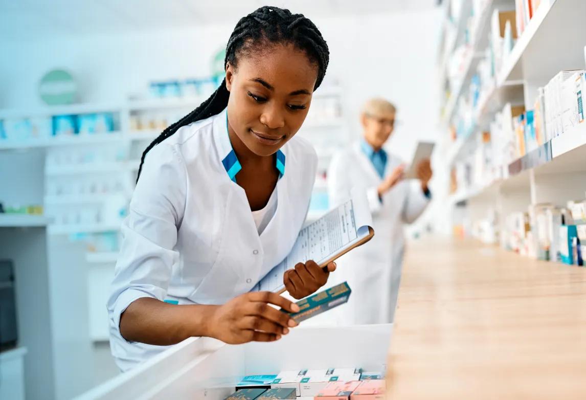 a pharmacy technician II working next to a pharmacy technician in a pharmacy setting