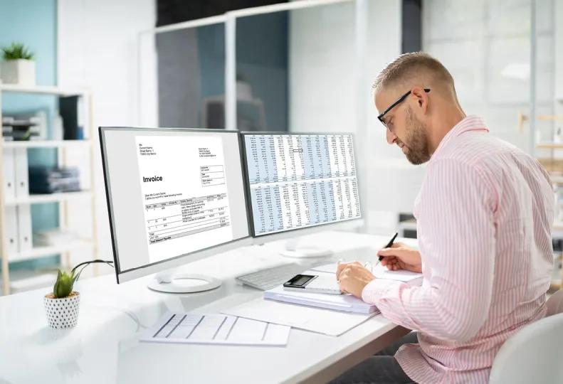 a medical billing specialist working on a computer in a healthcare office after completing a medical billing and coding program