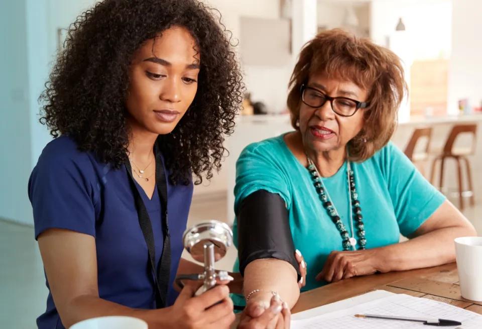 a woman gaining healthcare experience by taking another person’s blood pressure