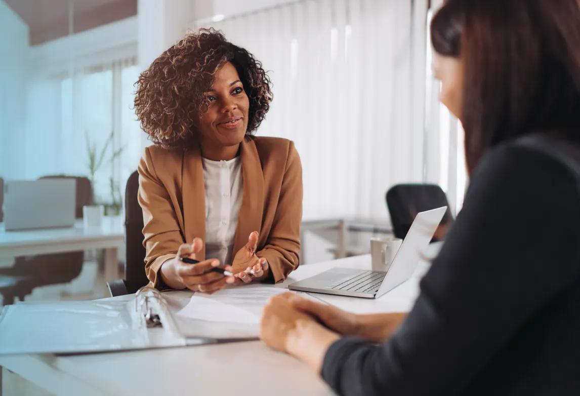 healthcare job applicant sitting at a table during an interview and explaining a resume gaphealthcare job applicant sitting at a table during an interview and explaining a resume gap