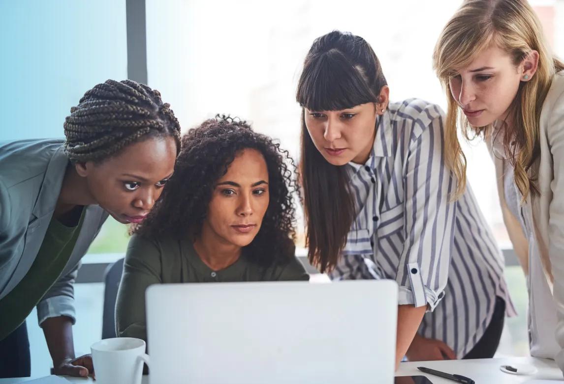 a group of people looking at a laptop to learn whether medical billing and coding is in demand
