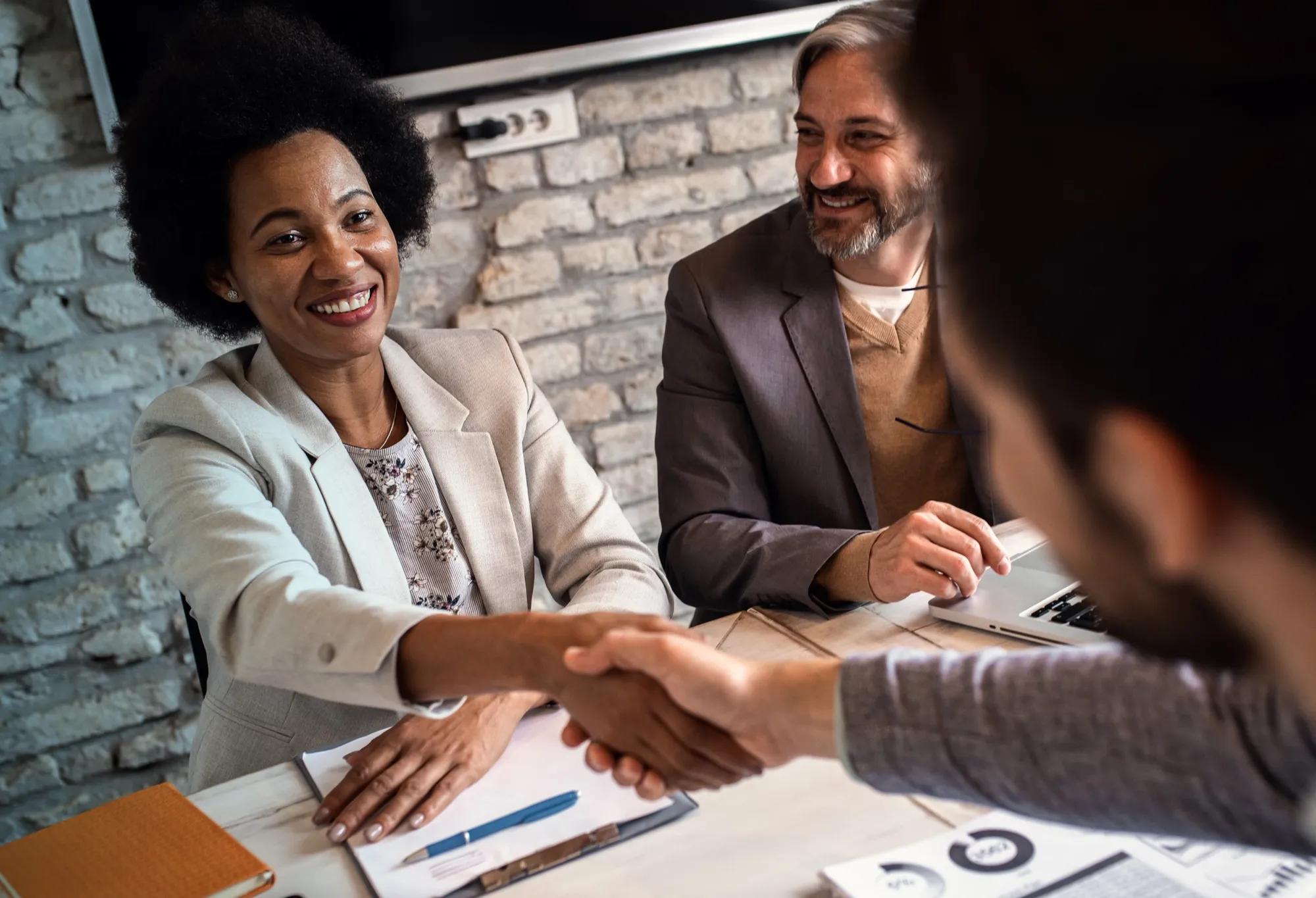An employee thinks, with hands folded, about the seven signs that it may be time to ask for a raise.