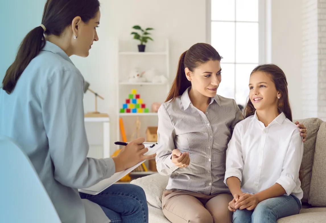 health and human services worker speaking with a mother and child 