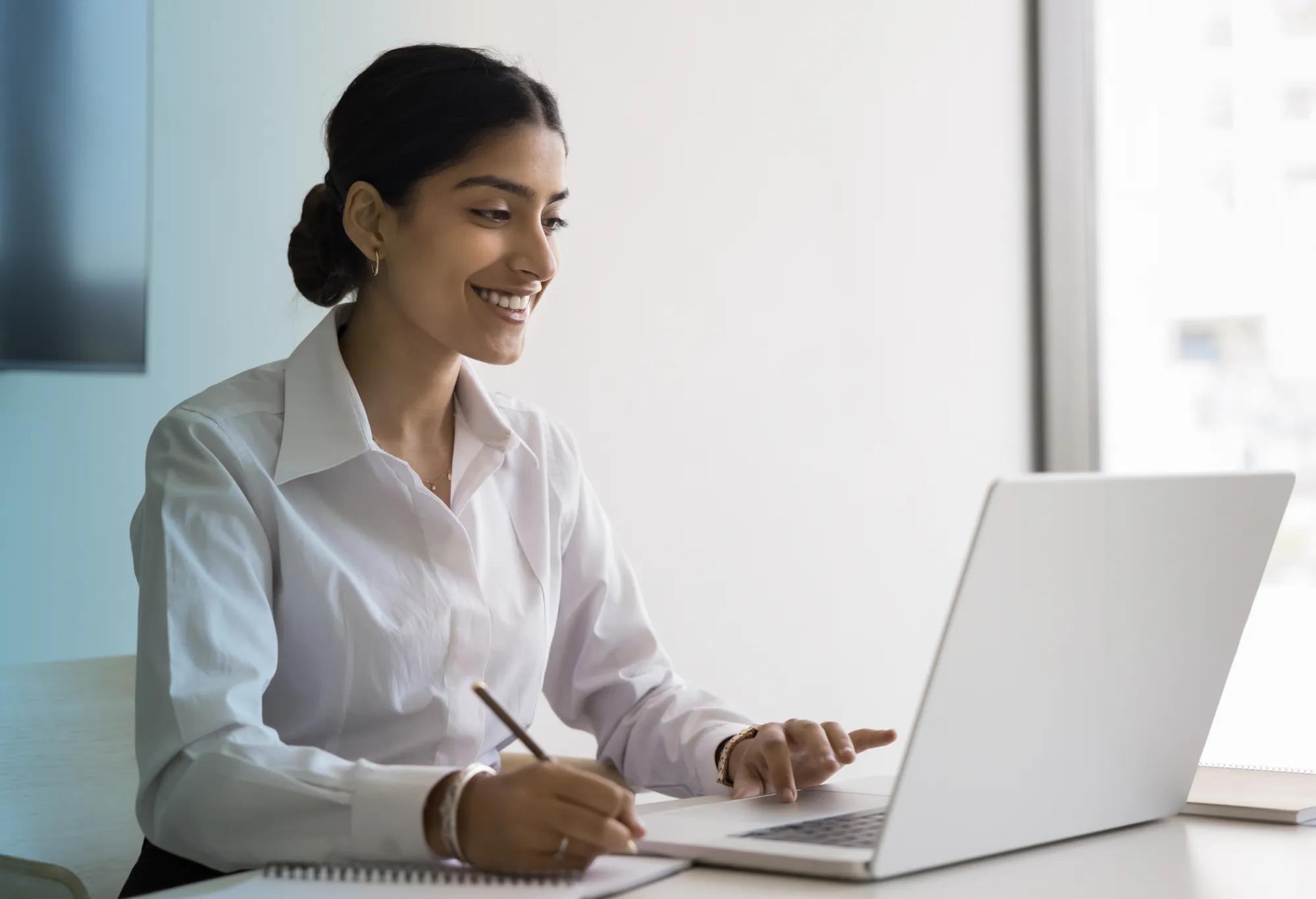 An adult learner taking notes in their online degree program